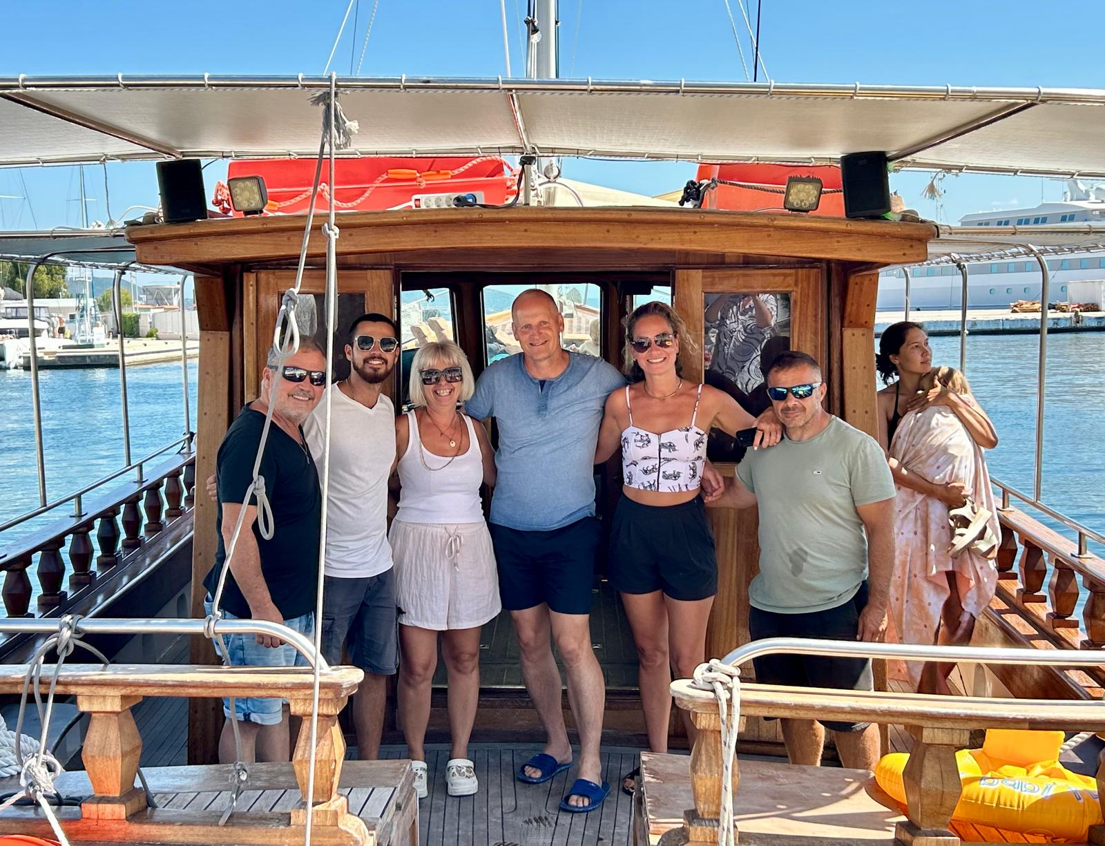 The crew of Amvrakikos Cruises with a happy guest